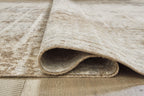 Light brown rug edge showing underside and ribbed backing, short pile