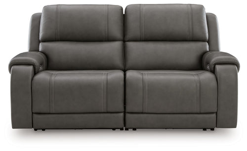 Dark gray power reclining loveseat with two wide seats, padded arms, and button-tufted backs