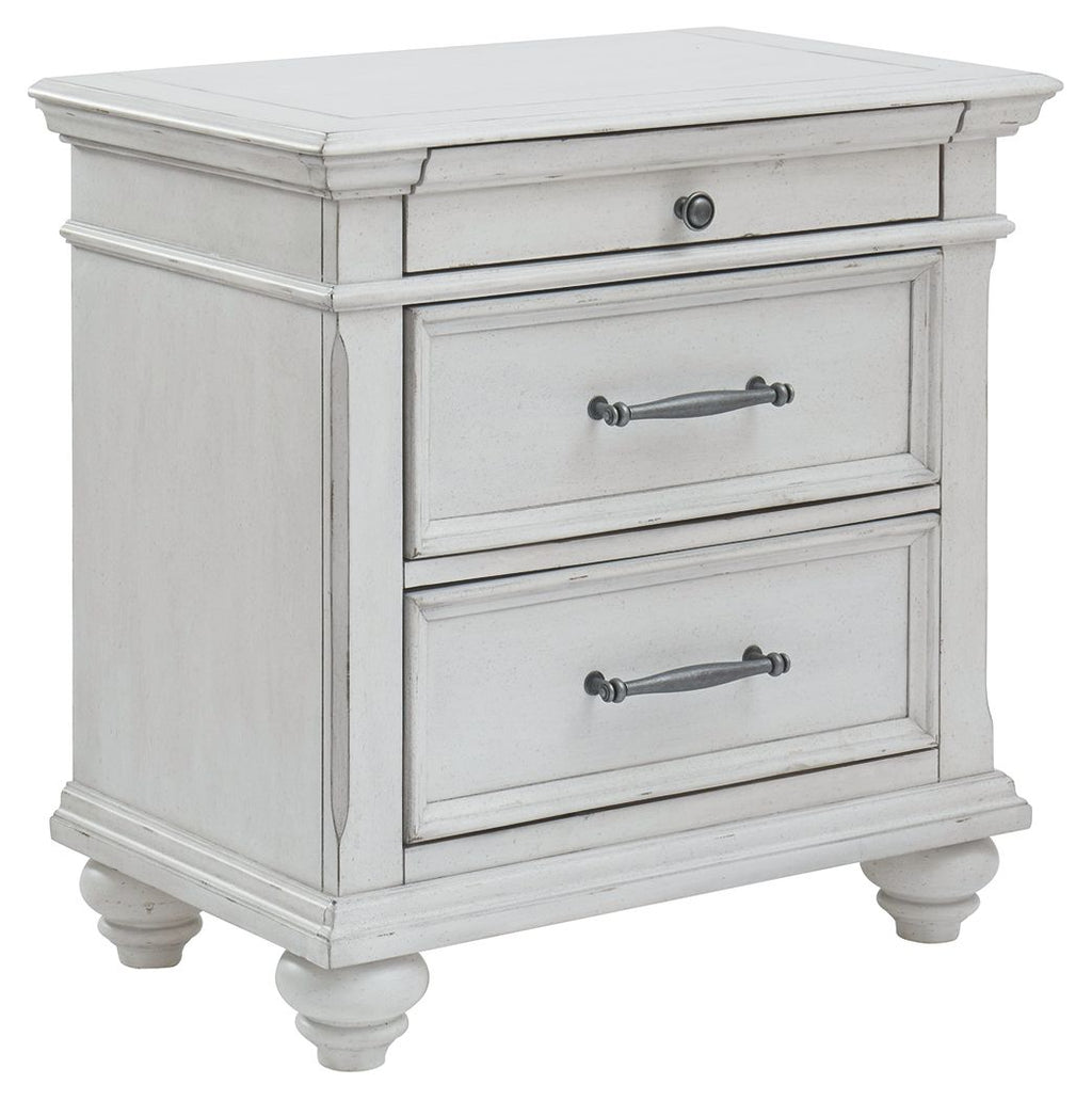 Whitewashed three-drawer nightstand with metal handles and turned legs