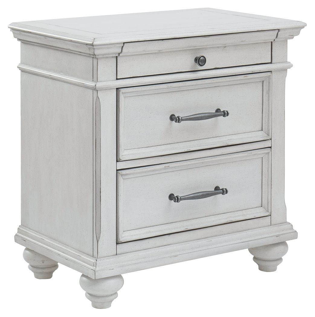 Whitewashed three-drawer nightstand with metal handles and turned legs