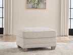 Opal fabric ottoman in front view with domed top and wooden feet