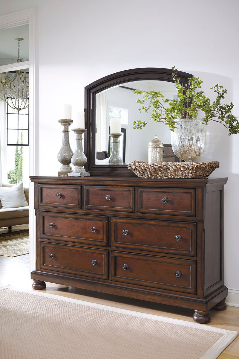 Dark brown dresser with mirror, multiple drawers, and paneled cabinet front