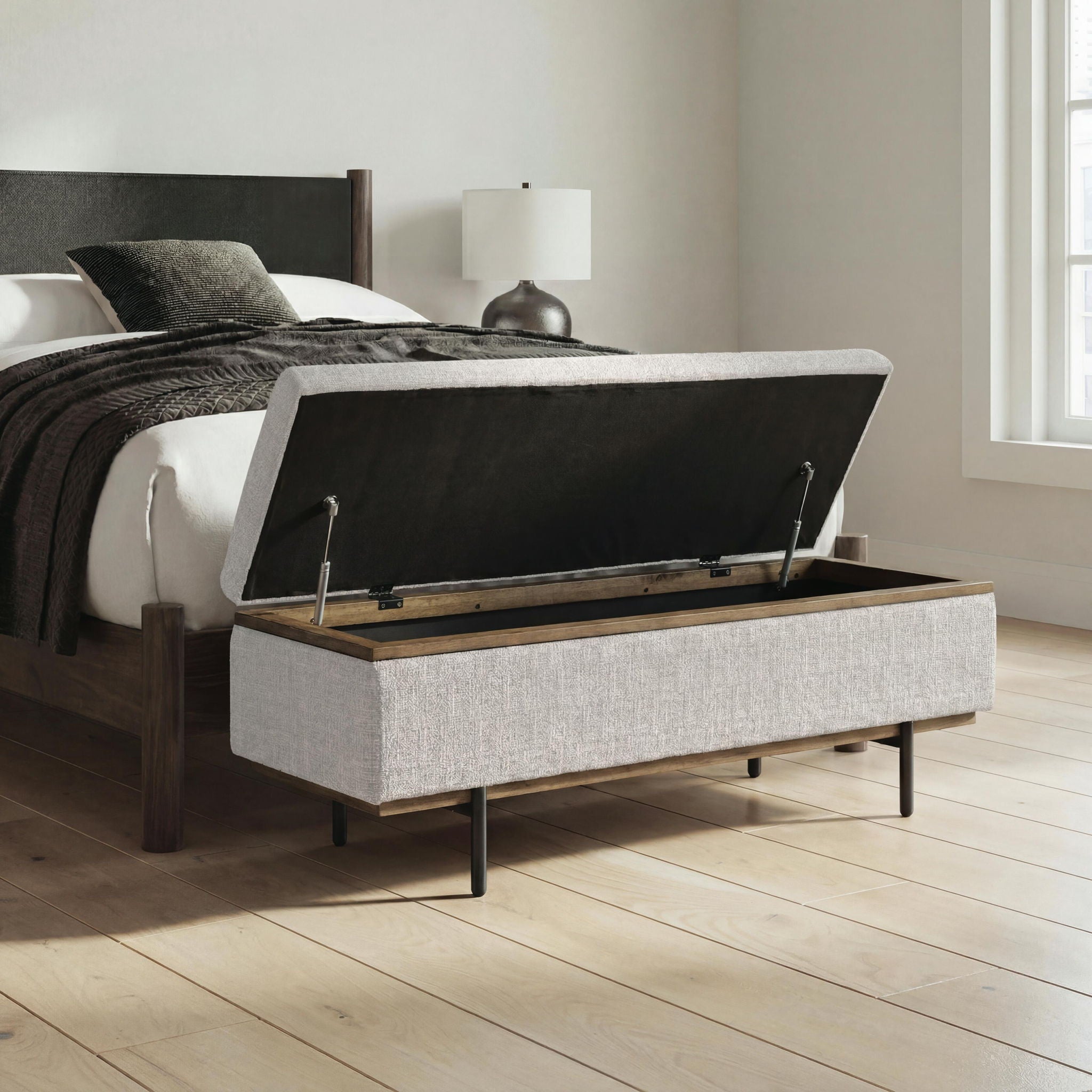 Stone upholstered storage bench with open lid and dark metal lift supports