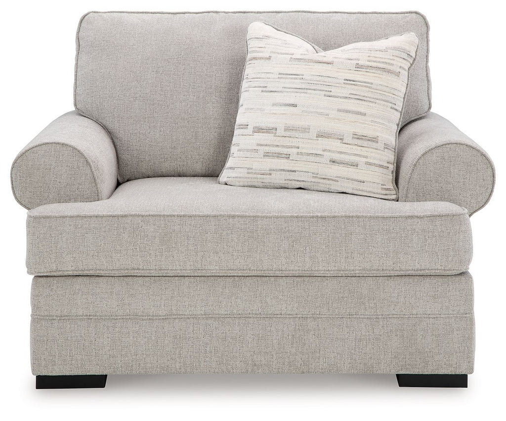 Light gray chair and a half with two rounded arms and striped throw pillow
