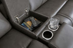 Dark gray reclining sofa console with storage compartments, remote, and cup holder