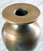Bronze metal vase top view, showing round opening and dark interior, brushed patina surface.