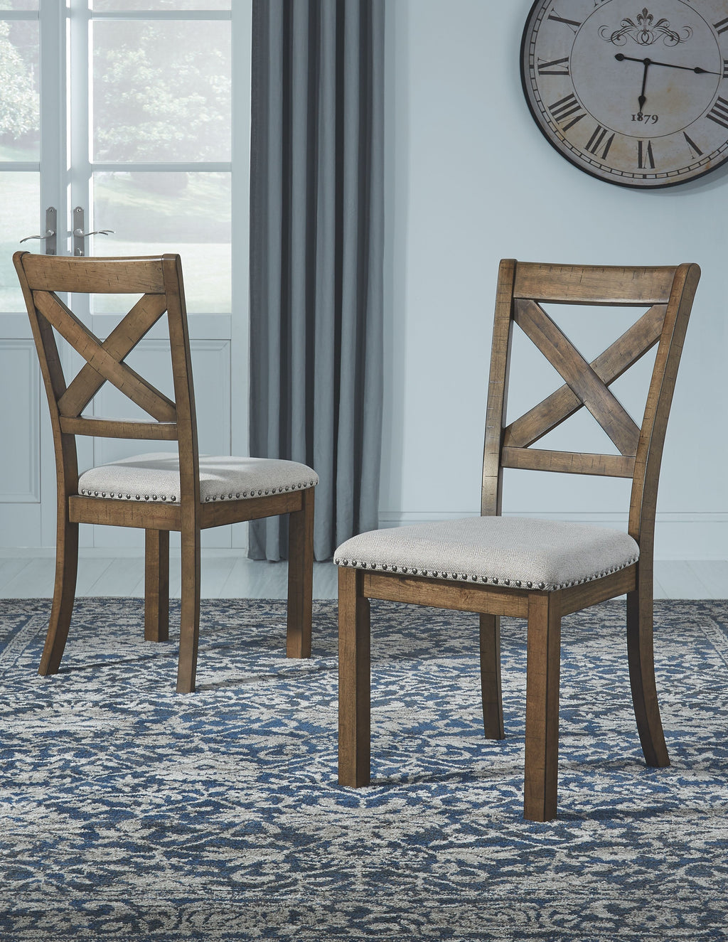 Dining chairs with X-back design and light seats, dark wood frames on patterned rug