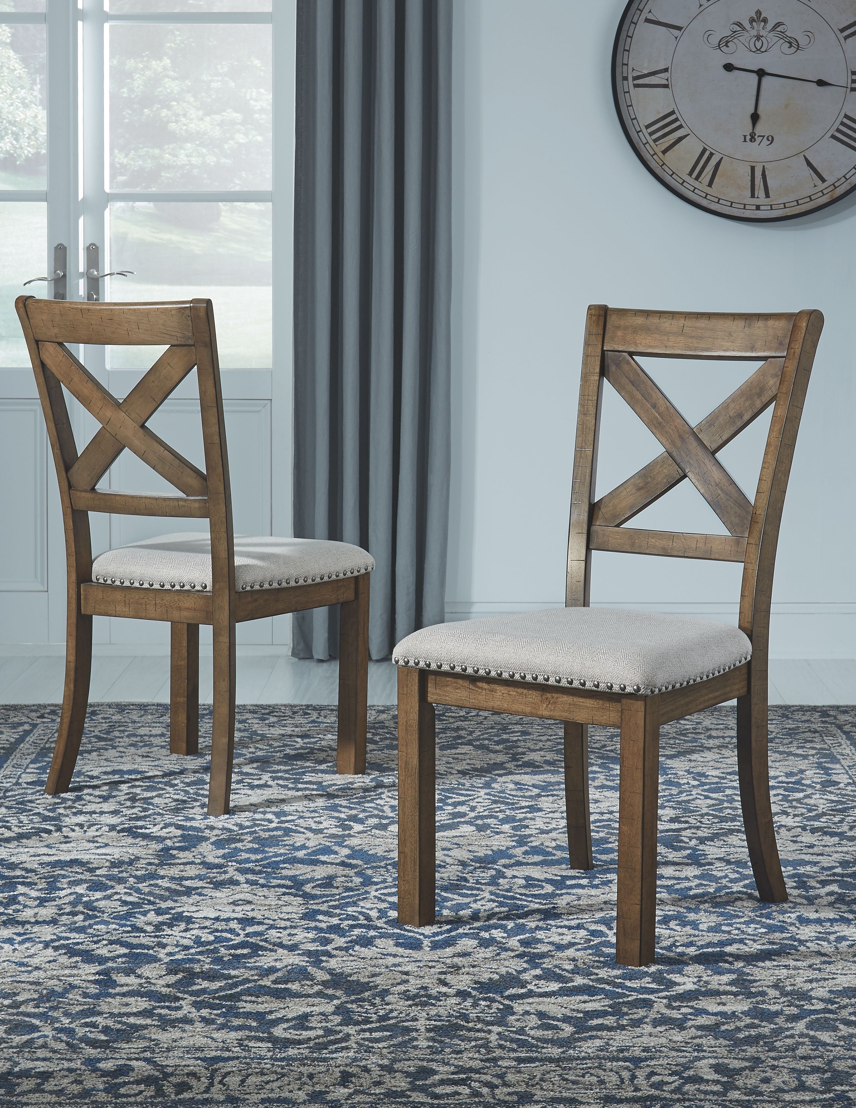 Dining chairs with X-back design and light seats, dark wood frames on patterned rug
