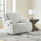 White rocker recliner chair with ribbed upholstery and rounded cushioned arms