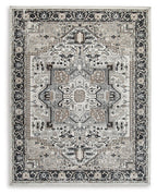 Light gray area rug with black and beige ornate medallion pattern, border edges