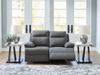 Dark gray reclining loveseat with rounded armrests and split seat back cushions