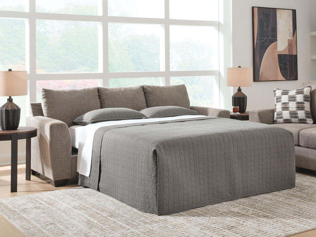 Gray sofa sleeper with pulled-out mattress and padded armrests