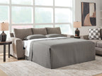 Gray sofa sleeper with pulled-out mattress and padded armrests