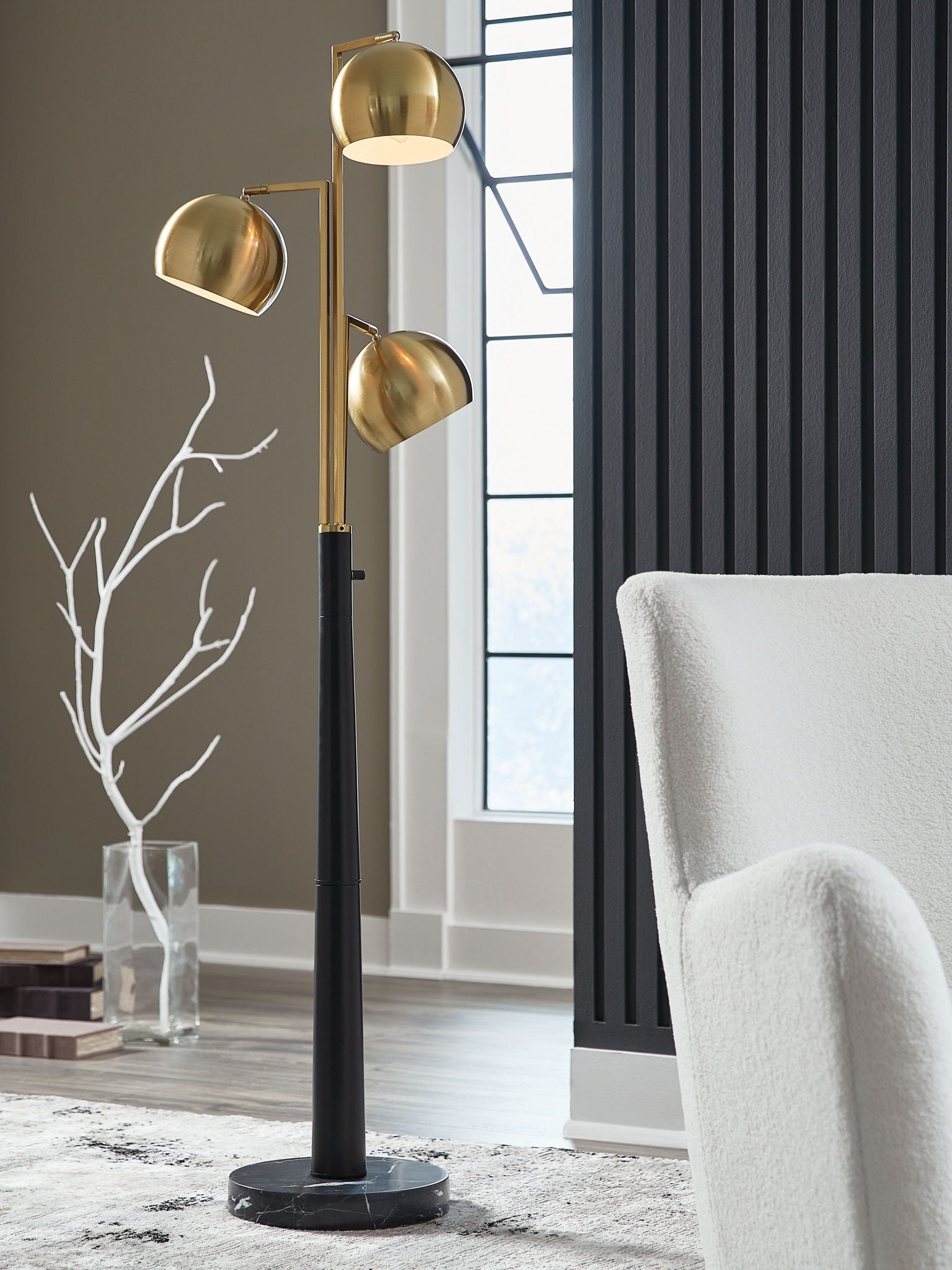 Gold floor lamp with three round shades, black pole, and round base