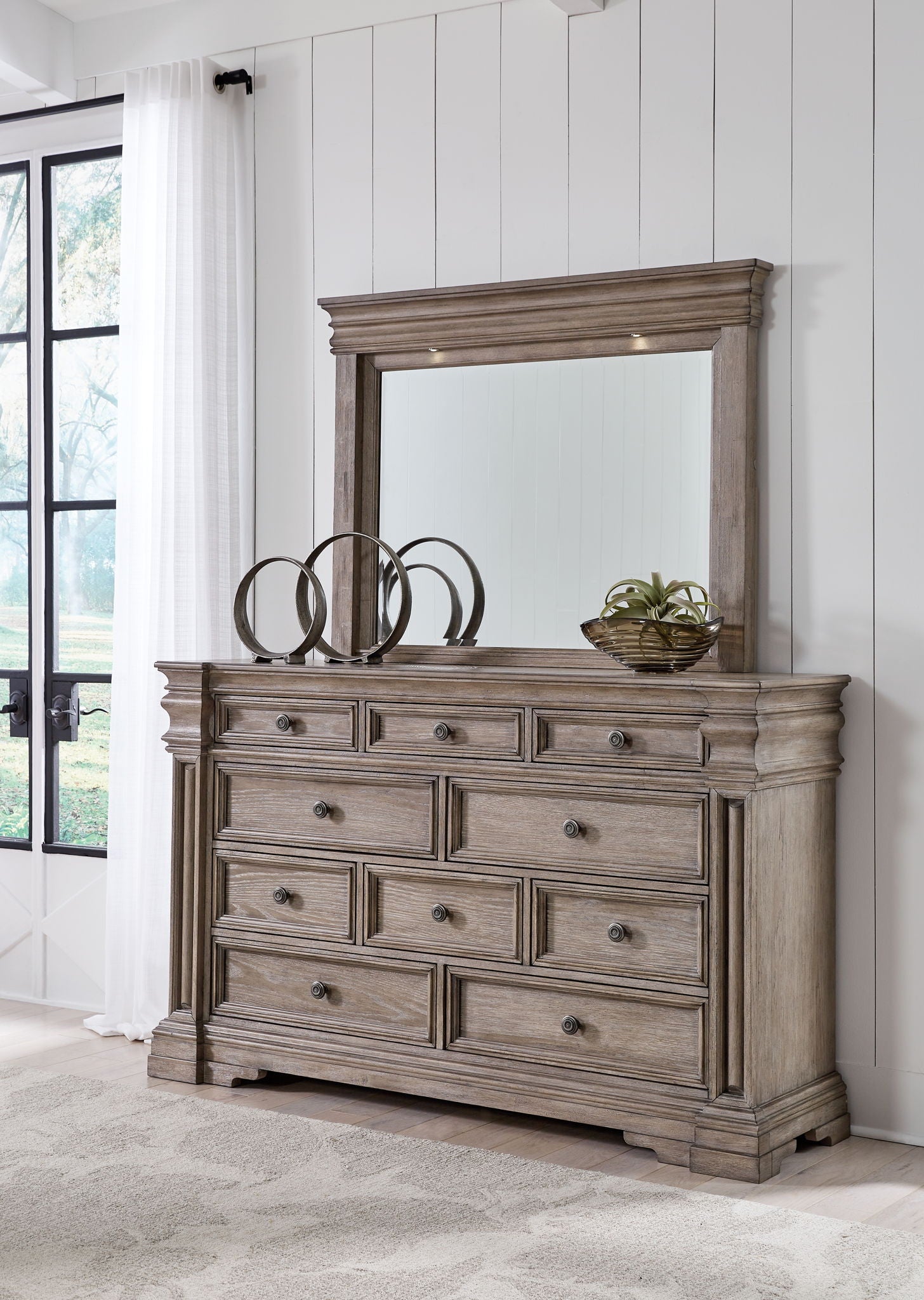 Gray wood dresser with mirror, paneled frame, and multiple drawer fronts