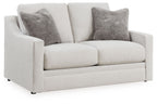 Chalk upholstered loveseat with two dark gray accent pillows and squared arms