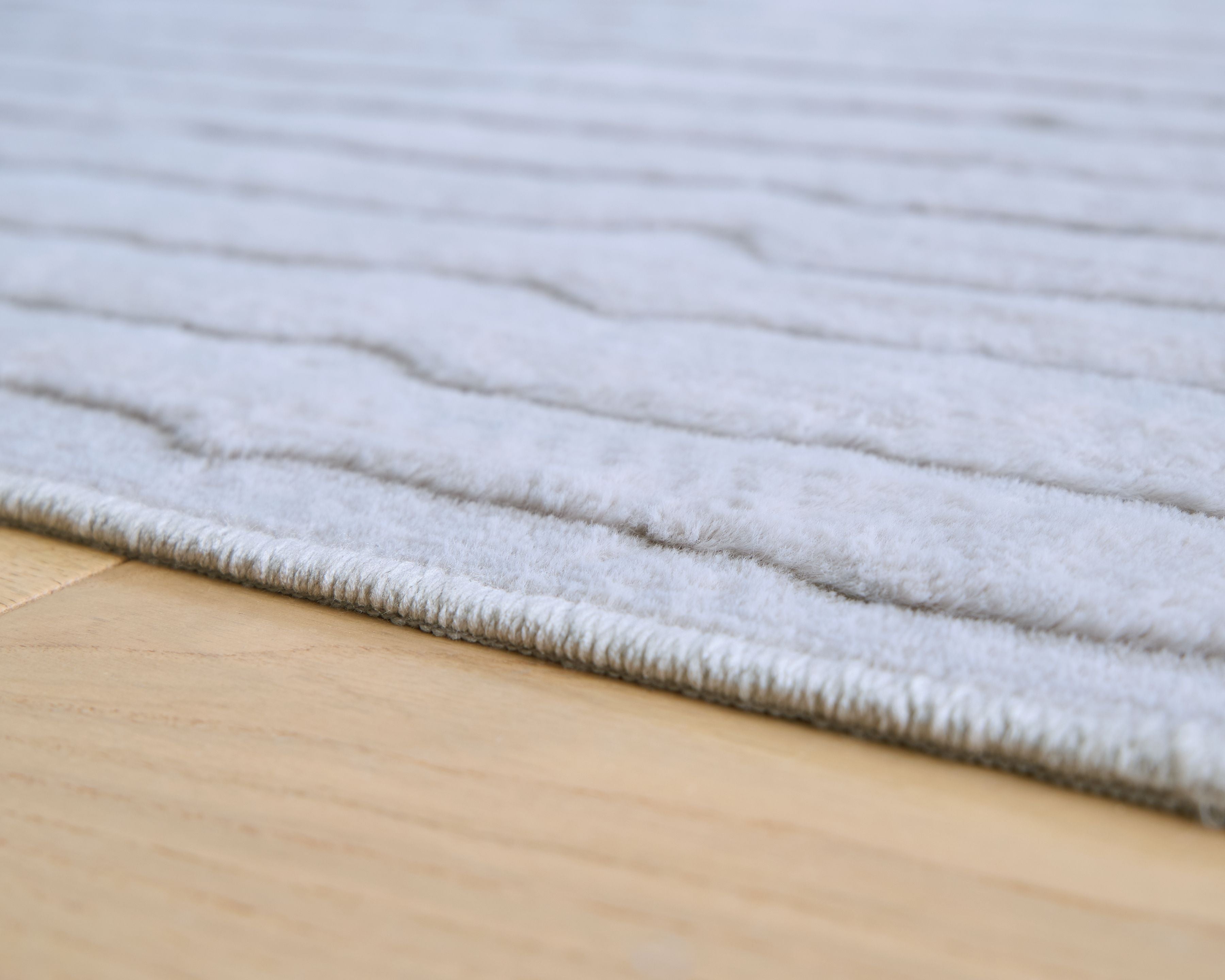 Gray washable rug with low pile and subtle stripe texture along the surface