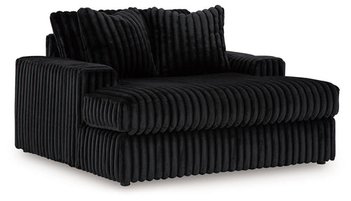 Oversized chaise with ribbed dark fabric, rolled armrests and thick seat cushion.
