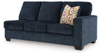 Ink blue fabric sofa with right-side arm and patterned throw pillow detail
