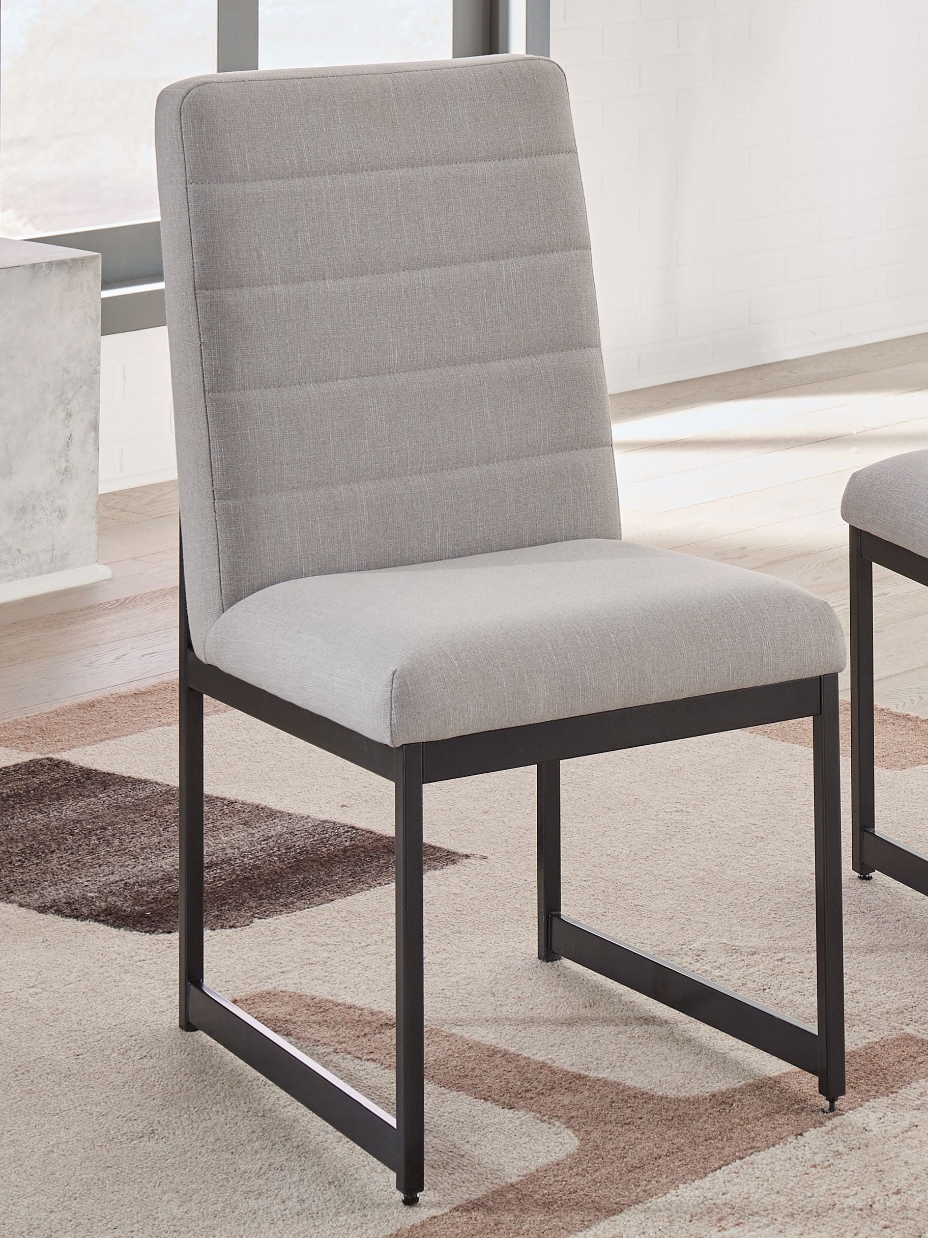 Dining side chair with padded back and seat, dark frame, light neutral upholstery