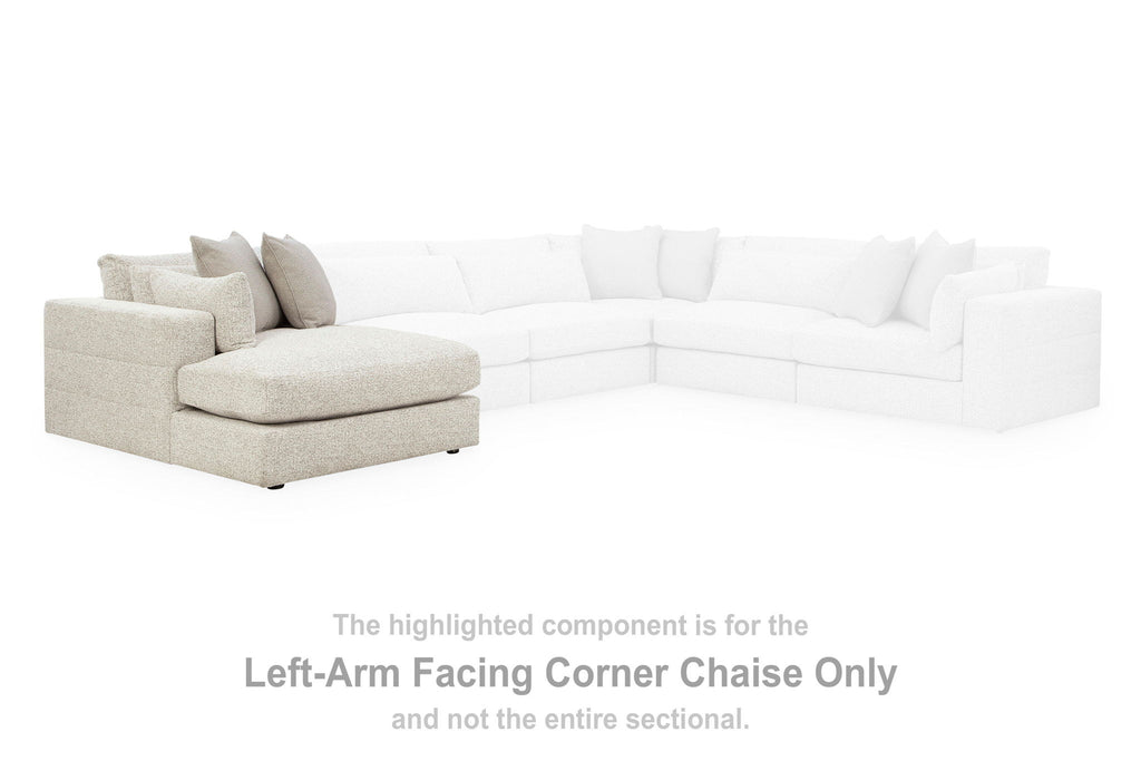 Left-arm facing corner chaise section with light fabric cushions and multiple back pillows