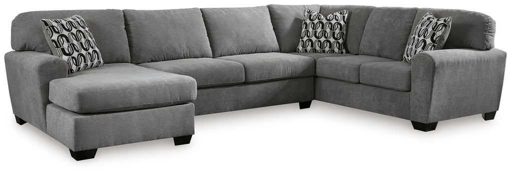 Gray sectional sofa with corner chaise, three cushions, and patterned accent pillows