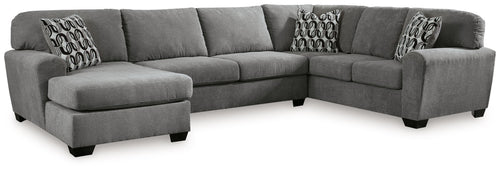 Gray sectional sofa with corner chaise, three cushions, and patterned accent pillows