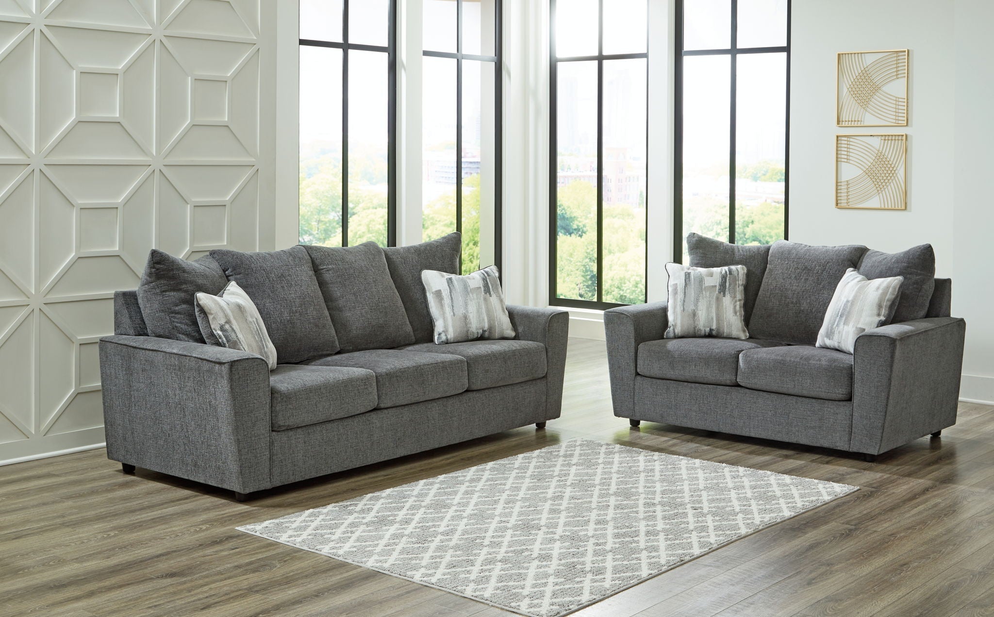 Dark gray fabric loveseat set with two loveseats and matching ottoman.