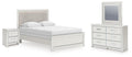 Upholstered panel bed in light fabric with white bedding and two side tables, dresser