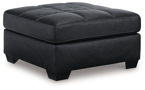 Oversized accent ottoman in dark carbon faux leather with tufted top and square base