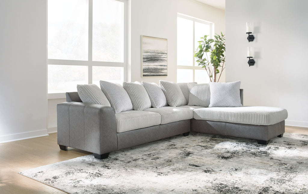 Light gray sectional sofa with chaise corner and striped throw pillows.