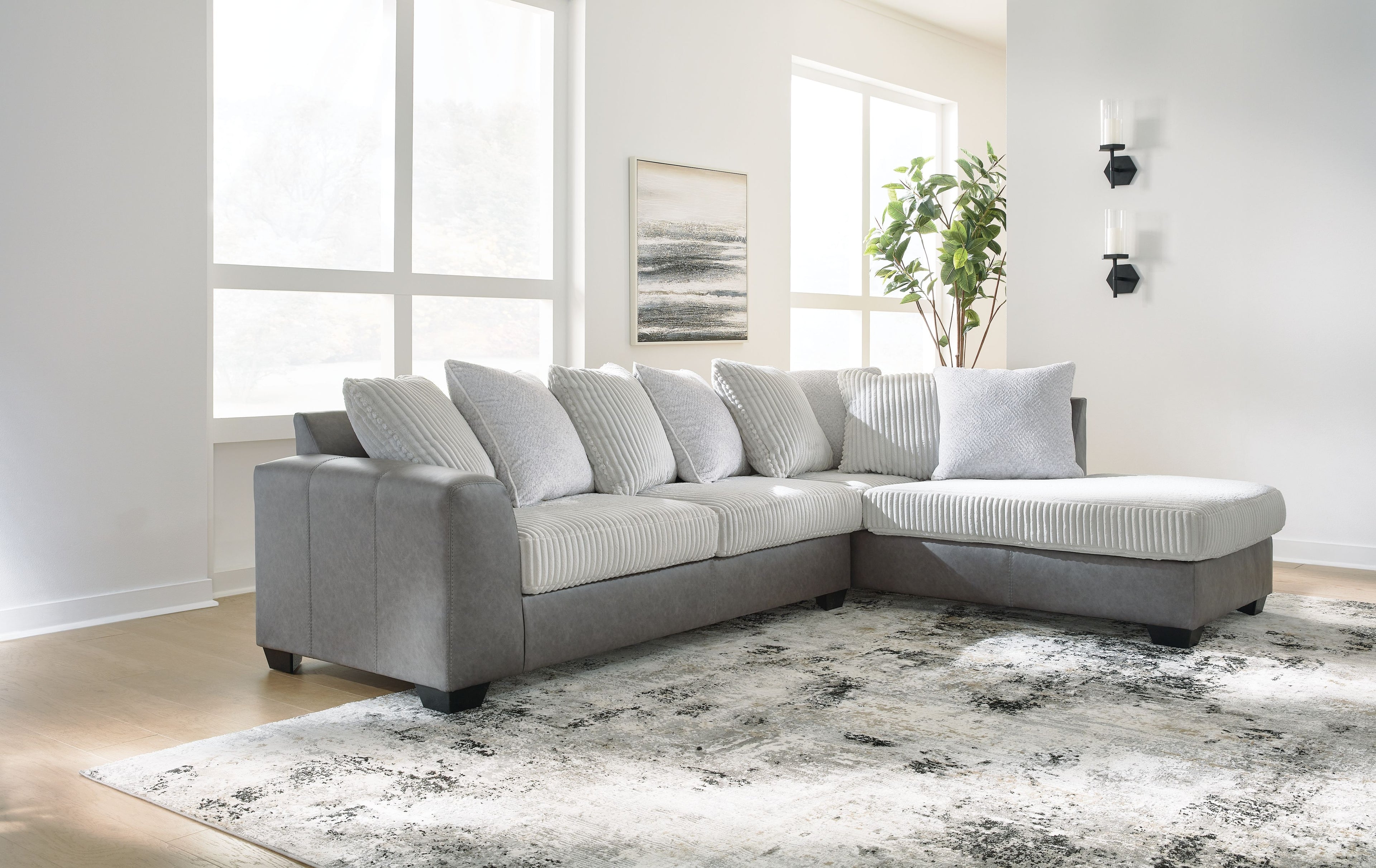 Light gray sectional sofa with chaise corner and striped throw pillows.