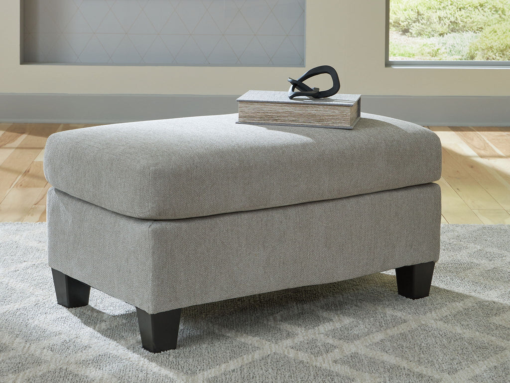 Taupe upholstered ottoman with padded top and dark tapered legs