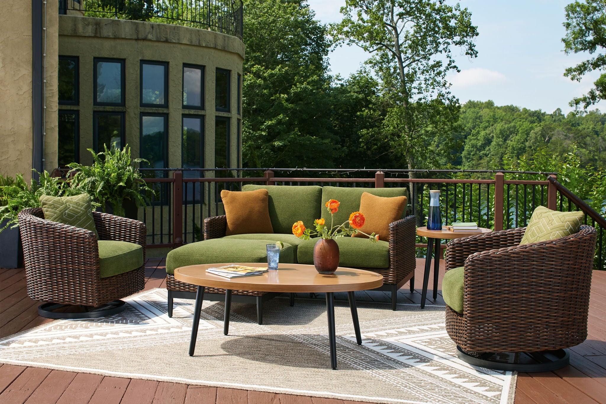 Wicker lounge set with sofa, two armchairs, and round coffee table with decorative items