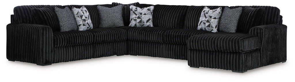 Black corded sectional sofa with chaise and ottoman, striped accent pillows