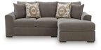 Gray sectional sofa with chaise on right side and two patterned throw pillows