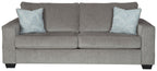 Alloy stationary sofa with square arms, tufted back, and two light patterned throw pillows