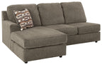 Gray sofa chaise with square armrests, tufted cushions, and patterned throw pillow