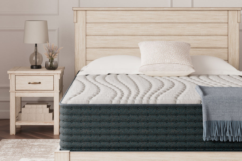 Hybrid mattress with dark gray quilted top and white pillows