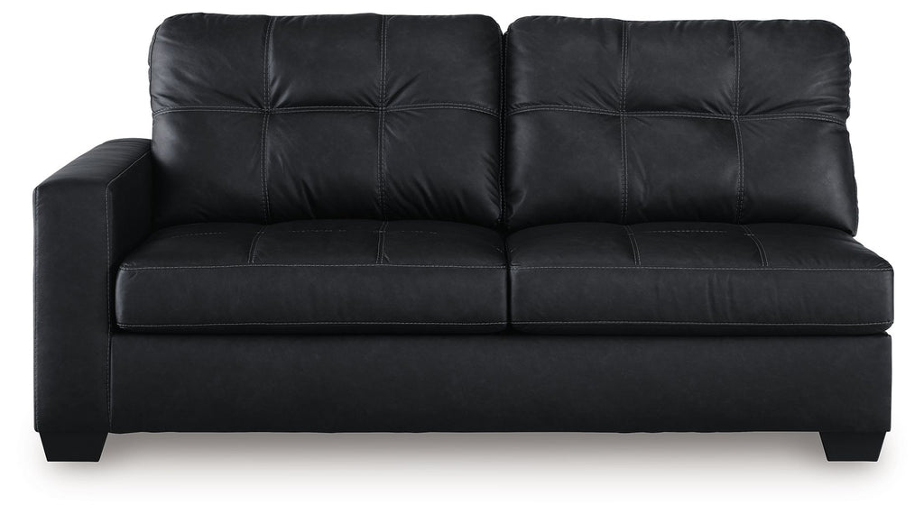 Dark sofa with tufted back, flat seat cushions, and boxy arms