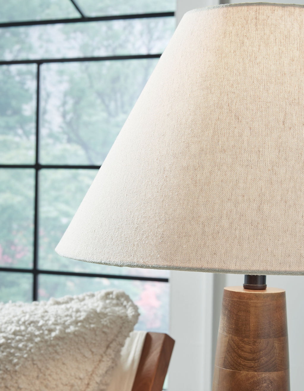Cream fabric lamp shade over dark brown tapered wooden base