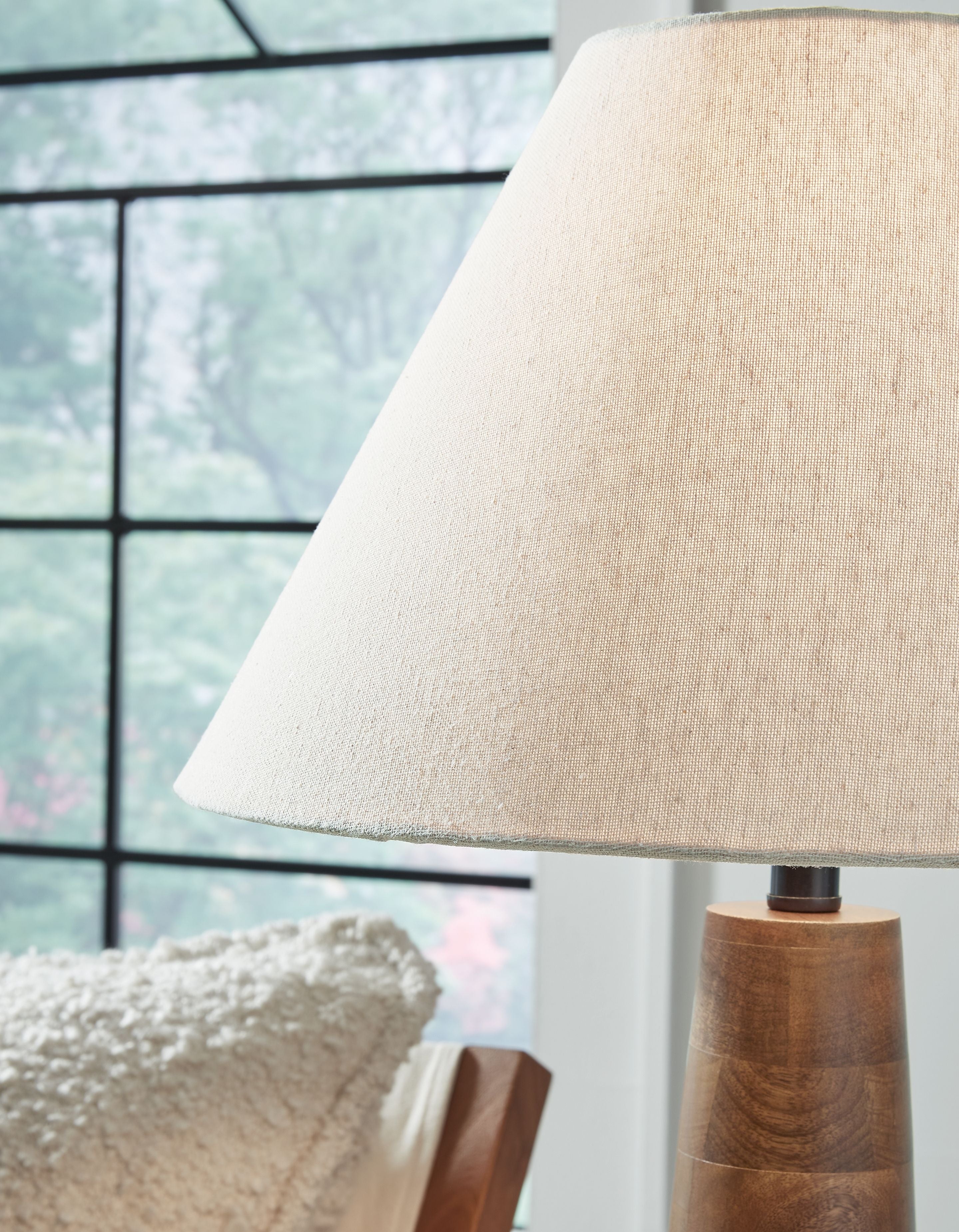 Cream fabric lamp shade over dark brown tapered wooden base