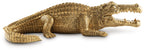 Antique gold crocodile sculpture in profile, ribbed scales and curled tail