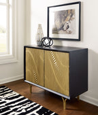Accent cabinet with gold fluted doors and dark body; vase on top, gold legs
