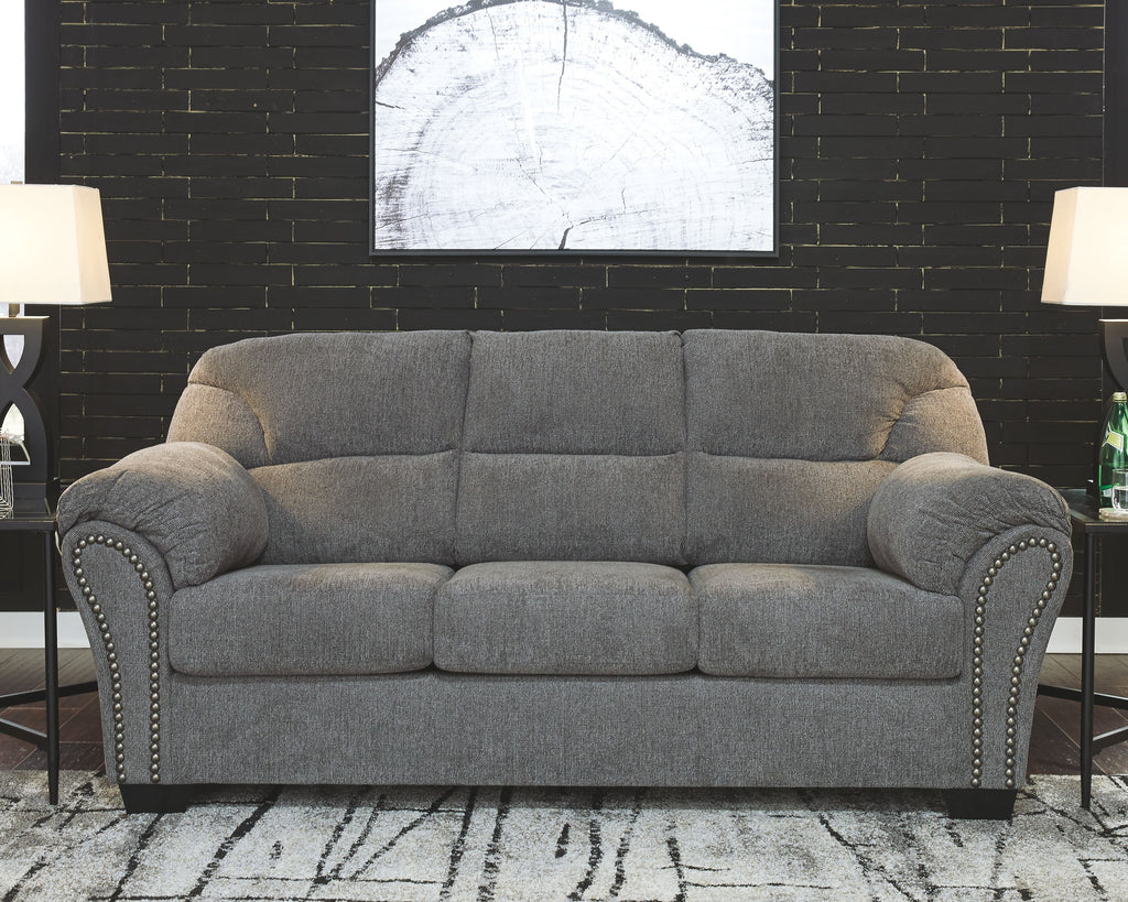 Pewter gray fabric sofa with button-tufted seat, curved arms, and nailhead trim