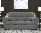 Pewter gray fabric sofa with button-tufted seat, curved arms, and nailhead trim
