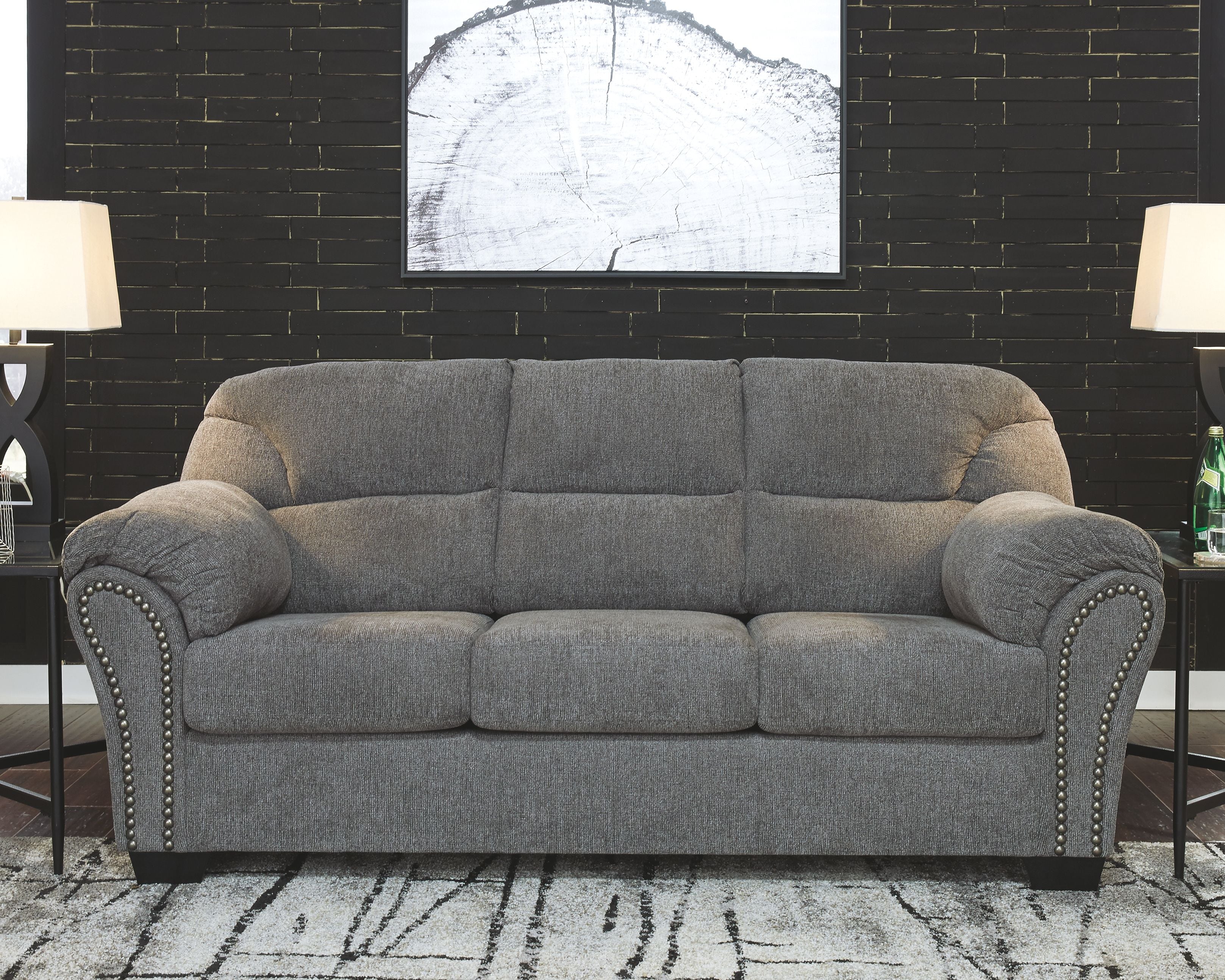 Pewter gray fabric sofa with button-tufted seat, curved arms, and nailhead trim
