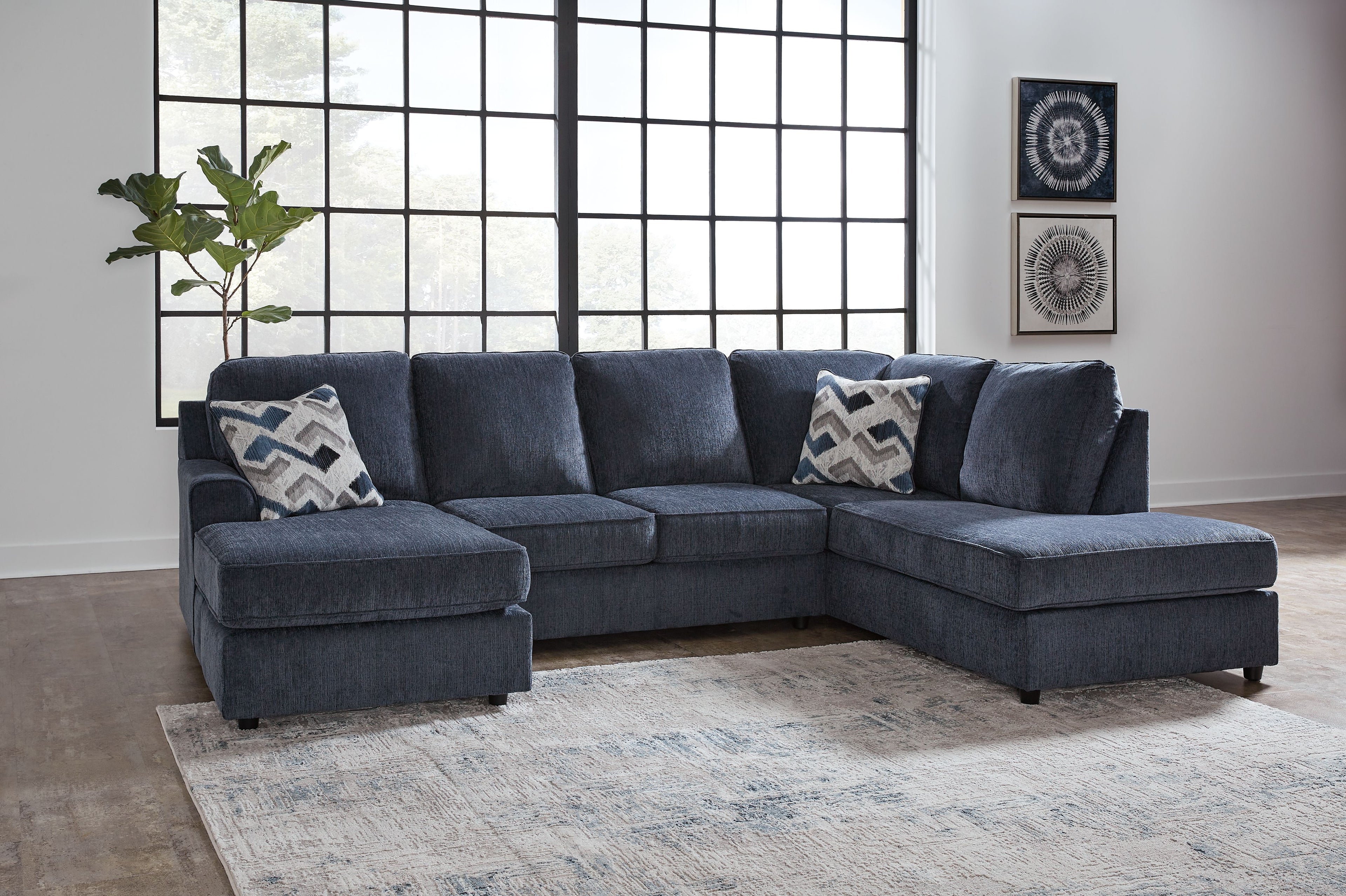 Cobalt blue sectional sofa with chaise and patterned throw pillows in a living room