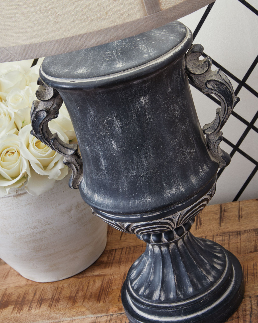 Antique black lamp base with scroll handles and cream drum shade