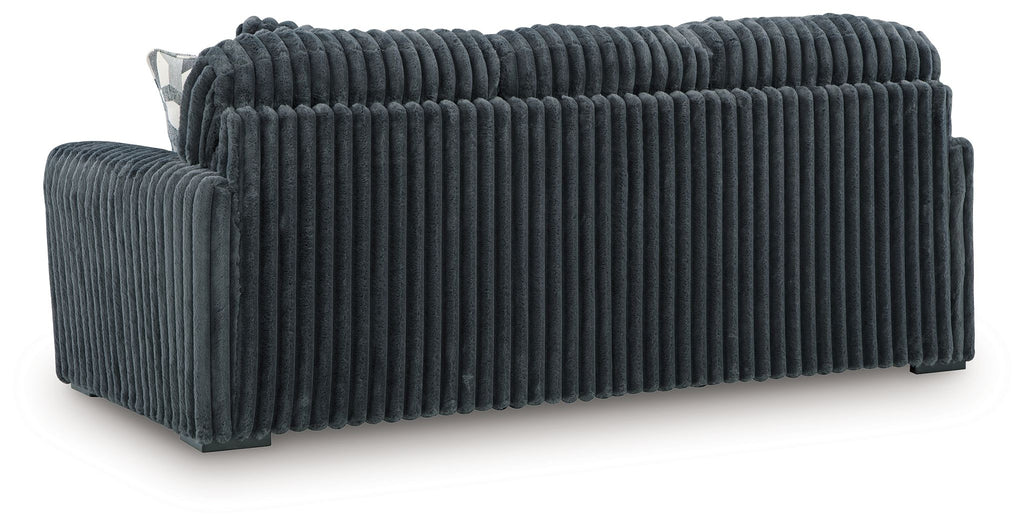 Dark gray corduroy sofa with track arms and a wide three-seat backrest, side view.